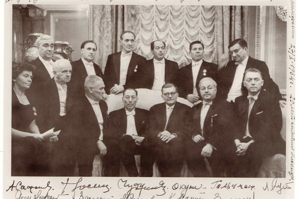 Dimitrij Šostakovič a Karl Eliasberg s muzikanty, kteří se účastnili provedení Sedmé symfonie v obléhaném Leningradu. Fotografie vznikla po koncertu konanému k 20. výročí ukončení blokády Leningradu 27. ledna 1964.