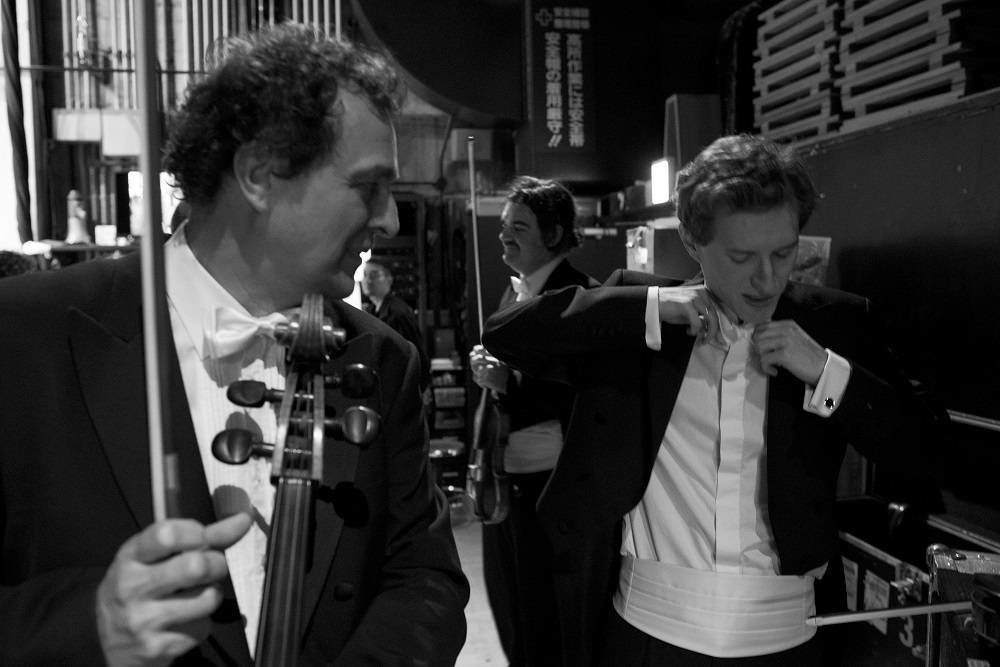 Before stepping out on the platform, Josef Špaček Sr. is checking whether his eponymous son, the leader of the Czech Philharmonic, has tied his bow tie correctly.